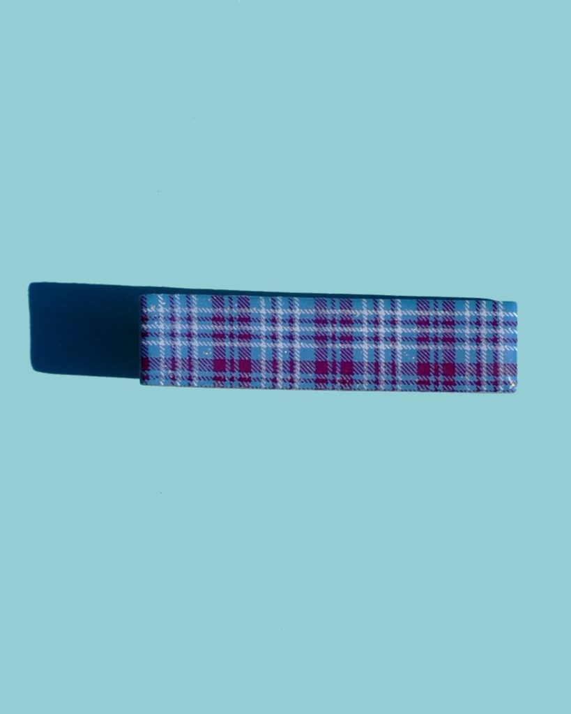 Barrette rectangulaire, d'un bleu glacé surmonté d'un motif à carreaux "check" lie de vin et blancs.