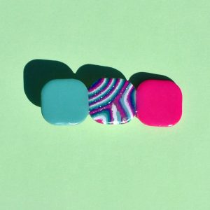 Barrette composée de trois carrés retro, un vert vague marine, un rose vif, un motif "à la dérive des astres".