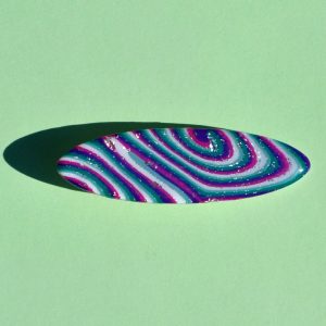 Barrette ellipse forme "planche de surf", au motif "à la dérive des astres".