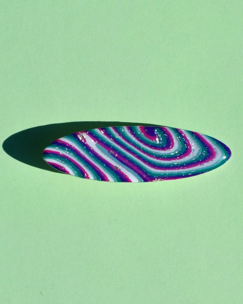 Barrette ellipse forme "planche de surf", au motif "à la dérive des astres".