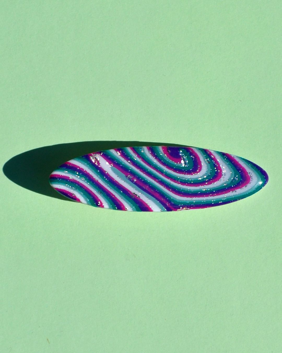 Barrette ellipse forme "planche de surf", au motif "à la dérive des astres".