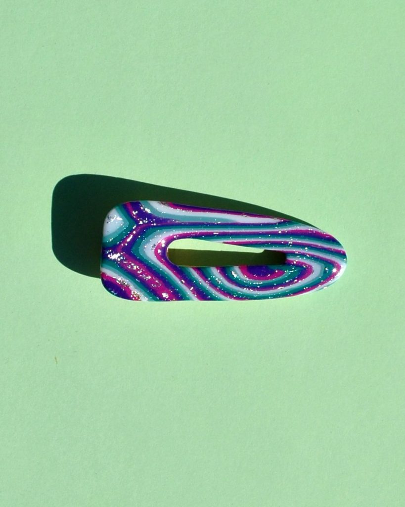 Barrette triangle classique aux bords arrondis, ajourée, au motif "à la dérive des astres".