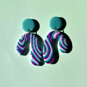 Paire de boucles d'oreilles en forme abstraite motif "à la dérive des astres" surmontée d'une puce ronde vert vague marine unie.