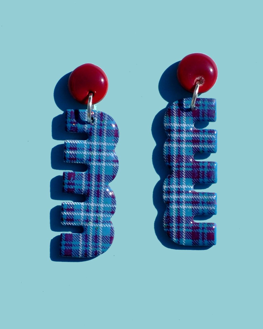Paire de boucles d'oreilles duo de forme abstraite rétro. Une petite puce ronde lie-de-vin surmonte un "double trois" allongé, à carreaux "check" lie-de-vin et blancs.