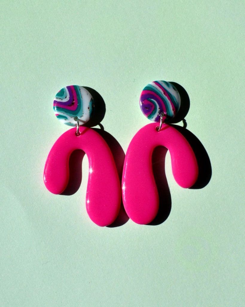 Paire de boucles d'oreilles en forme abstraite rose vif unie surmontée d'une puce ronde motif "à la dérive des astres".