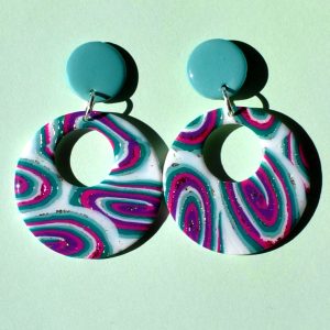 Paire de boucles d'oreilles en forme de rond rétro, ajourée, au motif "à la dérive des astres", surmontée d'une puce ronde unie vert vague marine.