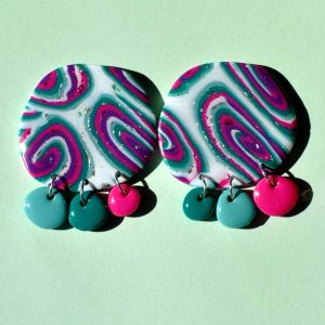 Paire de boucles d'oreilles en deux parties: un gros rond irrégulier motif "à la dérive des astres" surmontant trois petites pampilles ronds irrégulières unies de trois coloris différents (vert vague marine, vert émeraude et rose vif).