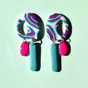 Paire de boucles d'oreilles "ovale" retro au motif "à la dérive des astres", surmontant deux pampilles asymétriques, la plus longue étant un "rectangle" uni vert vague marine, la plus petite "ovale" unie rose vif.