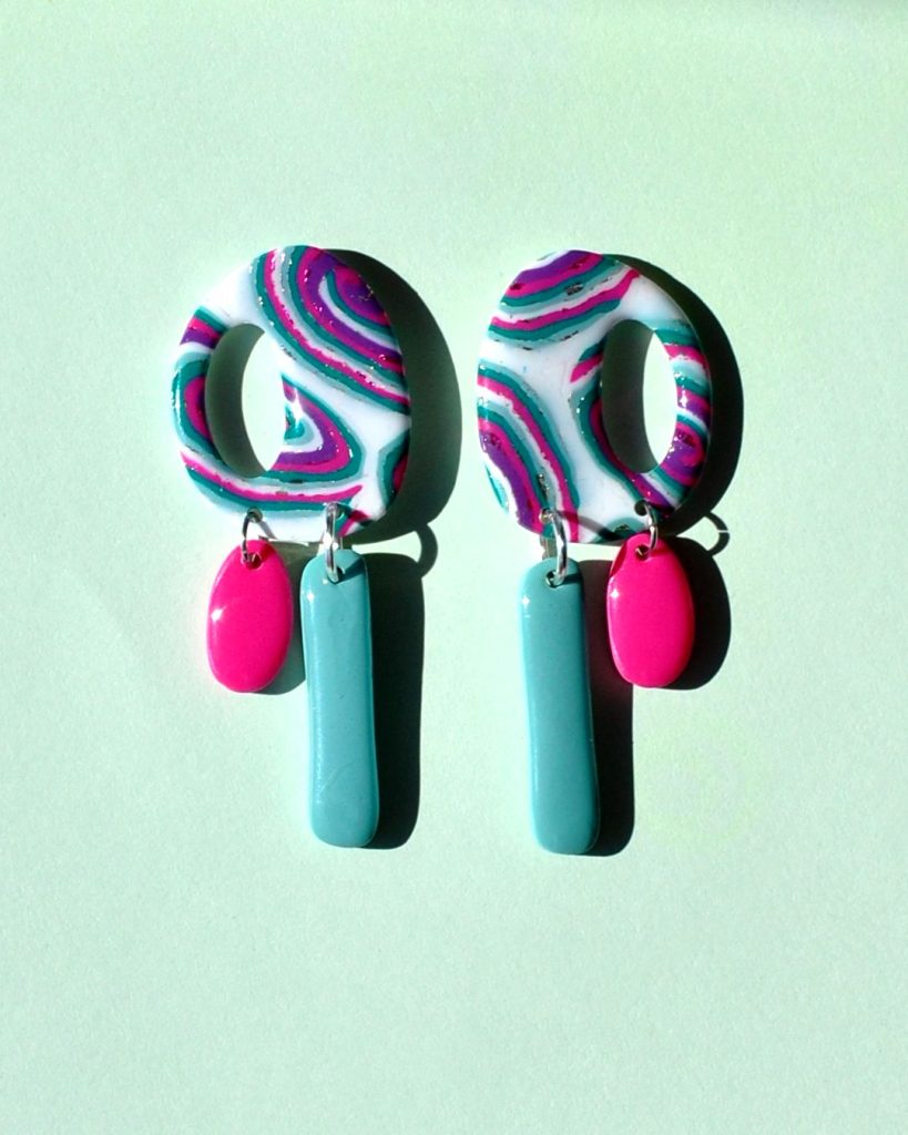 Paire de boucles d'oreilles "ovale" retro au motif "à la dérive des astres", surmontant deux pampilles asymétriques, la plus longue étant un "rectangle" uni vert vague marine, la plus petite "ovale" unie rose vif.