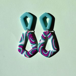 Paire de boucles d'oreilles composée de deux pentagones : un petit pentagone vert vague marine, surmontant un plus grand pentagone inversé au motif "à la dérive des astres".