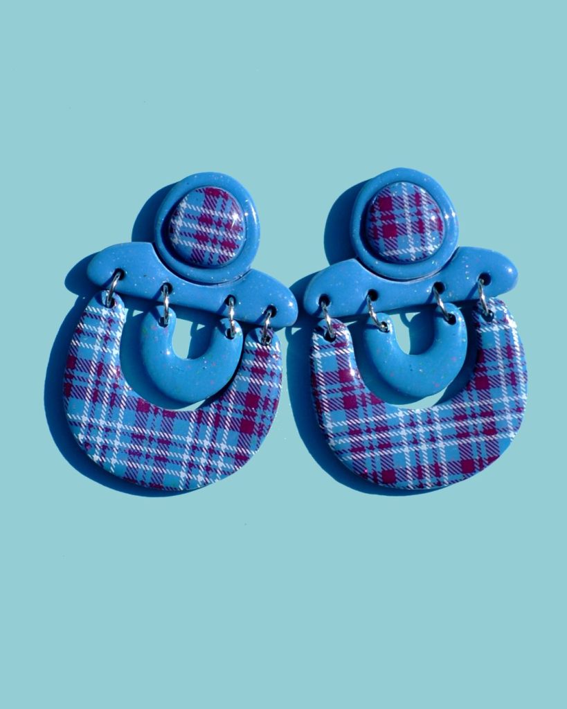 Paire de boucles d'oreilles complexe avec une attache surmontée d'un cabochon motif carreaux "check" lie-de-vin et blancs. L'attache surmonte deux "U", l'un bleu givré l'autre au motif à carreaux "check" lie-de-vin et blancs.