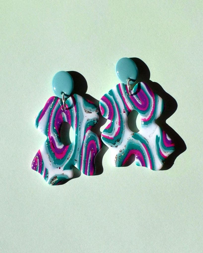 Paire de boucles d'oreilles composée d'une énorme "fleur trèfle à quatre feuilles" au motif "à la dérive des astres", surmonté d'une puce petit ovale uni vert vague marine.