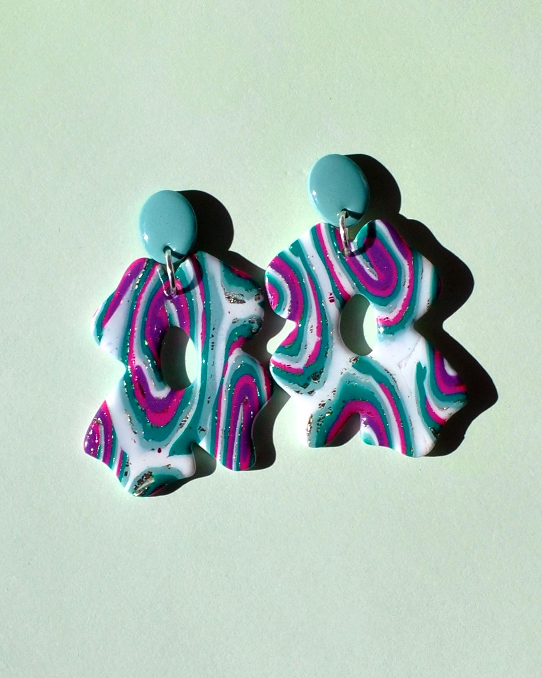 Paire de boucles d'oreilles composée d'une énorme "fleur trèfle à quatre feuilles" au motif "à la dérive des astres", surmonté d'une puce petit ovale uni vert vague marine.