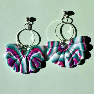 Paire de boucles d'oreilles en trois parties. Une petite puce en acier inoxydable, surmontant un cercle en acier inoxydable, surmontant une "moitié de fleur" ou un "papillon" au motif "à la dérive des astres".