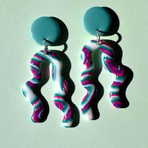 Paire de boucles d'oreilles en deux parties: une puce ronde unie vert vague marine surmonte un une ligne ondulante avec deux "bras" au motif "à la dérive des astres".