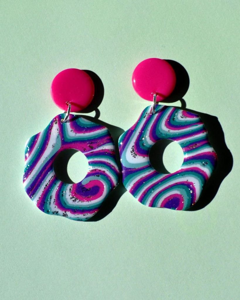 Paire de boucles d'oreilles en forme de "fleurs" abstraites motif "à la dérive des astres" surmontées d'une puce ronde rose unie.