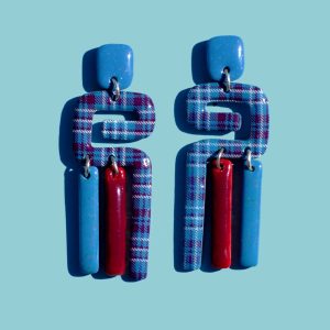 Paire de boucles d'oreilles en 3 parties: une petite puce rectangulaire en longueur bleue givrée, une forme abstraite "précolombienne" à carreaux "check" lie-de-vin et blancs, surmontant deux pampilles, une bleu givrée et une lie-de-vin.