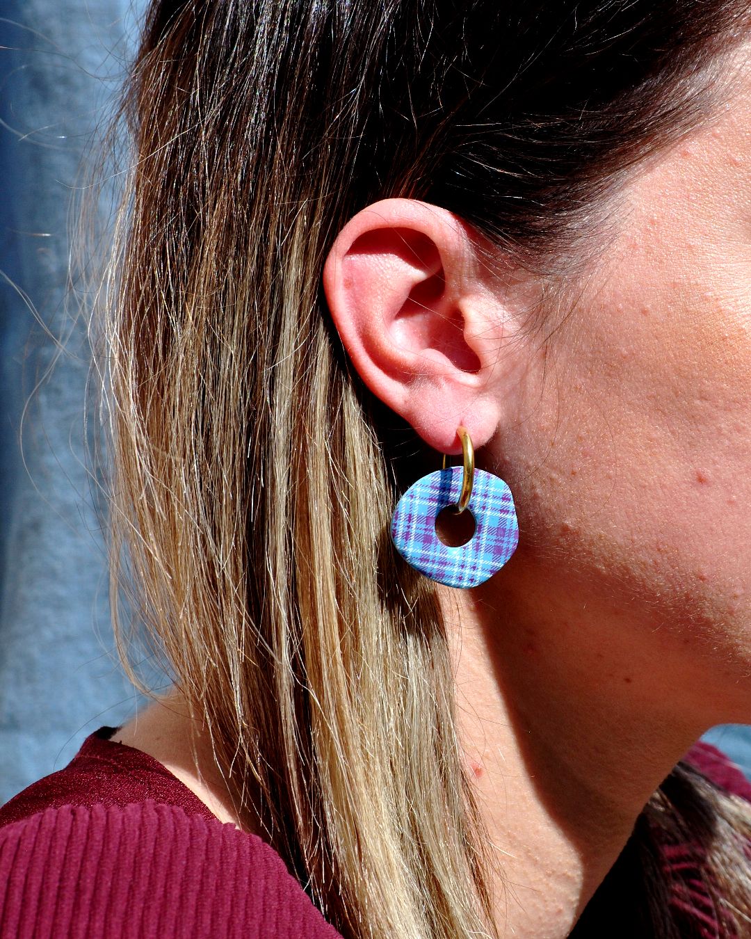 Boucle d'oreille portée avec créole dorée.