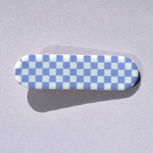 Barrette rectangle arrondi, au motif damier violet pâle sur fond blanc.