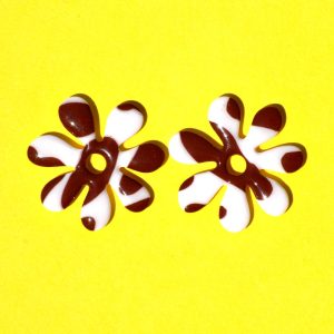 Pampilles interchangeables grande taille en forme de fleurs à sept pétales, motif avec tâches de vache brunes sur fond blanc.