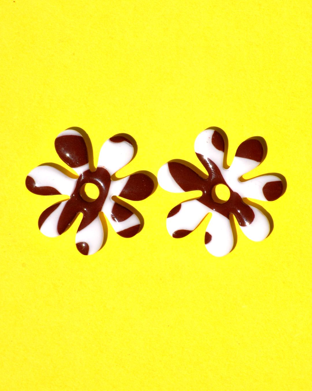 Pampilles interchangeables grande taille en forme de fleurs à sept pétales, motif avec tâches de vache brunes sur fond blanc.