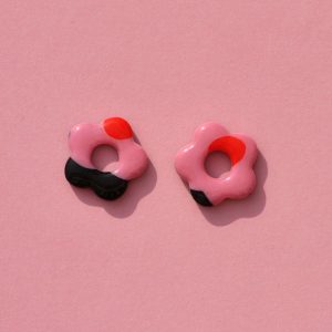 Pampilles interchangeables de taille moyenne en forme de fleurs à cinq pétales, motif à fleurs roses à six pétales à cœur rouge sur fond noir.