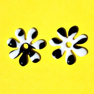 Pampilles interchangeables grande taille en forme de fleurs à sept pétales, motif avec tâches de vache noires sur fond blanc.