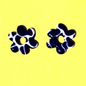 Pampilles interchangeables de "grande" taille en forme de fleurs classiques à six pétales irréguliers, motif avec tâches de vache noires sur fond blanc.