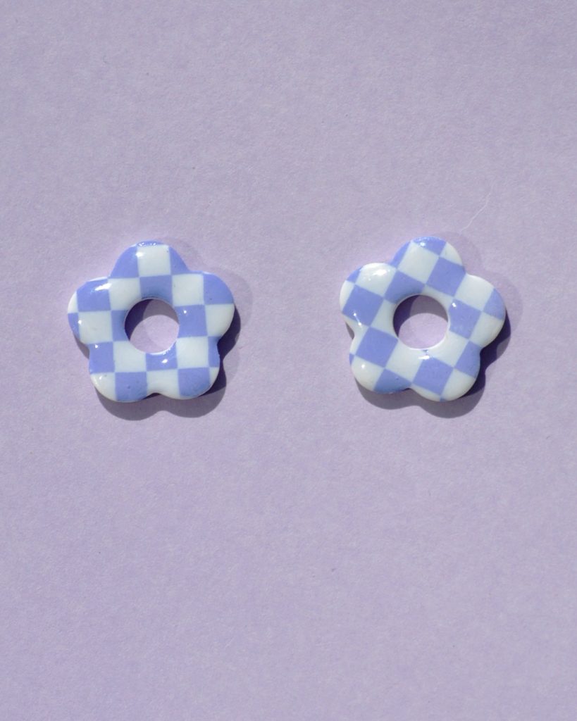 Pampilles interchangeables de taille moyenne en forme de fleurs à cinq pétales, motif damier violet sur fond blanc.