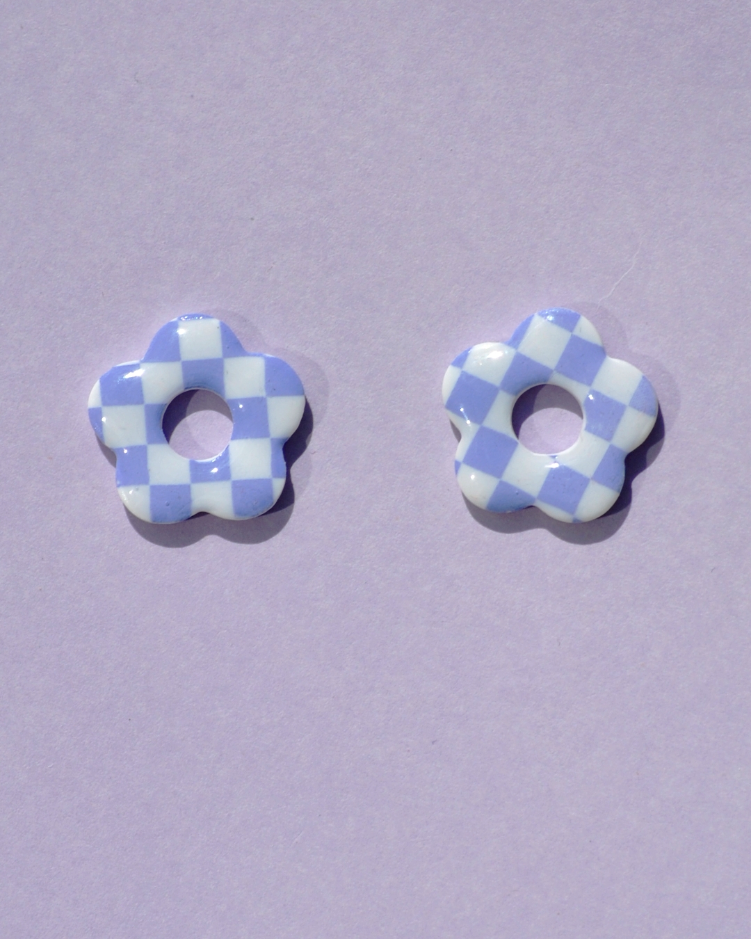 Pampilles interchangeables de taille moyenne en forme de fleurs à cinq pétales, motif damier violet sur fond blanc.
