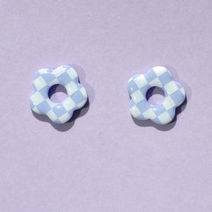 Pampilles interchangeables de taille moyenne en forme de fleurs à cinq pétales, motif damier blanc sur fond violet pâle.
