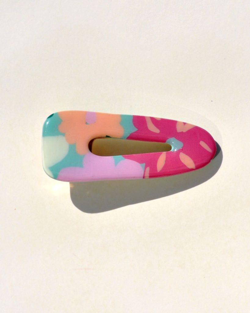 Barrette triangle classique aux bords arrondis, ajourée, à motif floral.