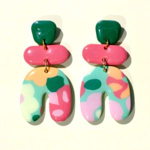 Paire de boucles d'oreilles en trois parties: une puce "carrée" arrondie vert foncé, surmontant un "rectangle" arrondi rose-rouge uni, surmontant un U à l'envers motif floral printanier.