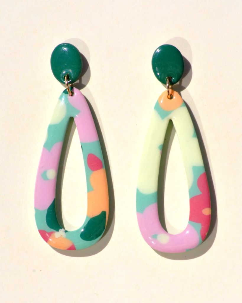 Paire de boucles d'oreilles en forme de "goutte" ajourée au motif floral printanier, surmontée d'une petite puce ovale unie verte foncée.