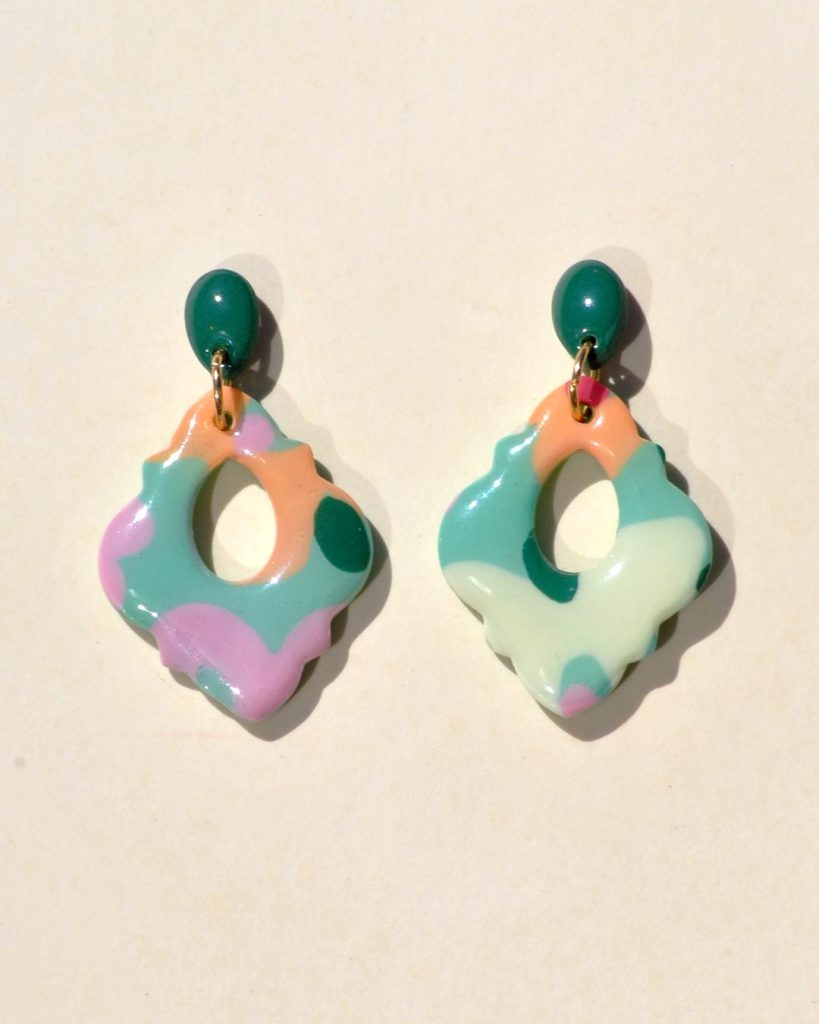Petite paire de boucles d'oreilles en forme de "carrelage azulejo festonné", ajouré au centre d'une mini goutte, au motif floral printanier. La boucle est surmontée d'une mini puce en forme de mini goutte.