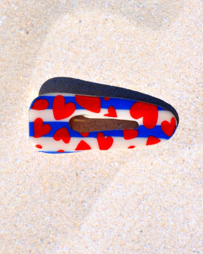 Barrette triangle classique aux bords arrondis, ajourée, à motif floral.