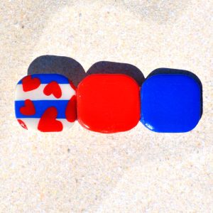 Barrette composée de trois carrés retro, un motif marinière avec cœurs rouges, un rouge vif et un bleu éclatant.