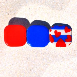Barrette composée de trois carrés retro, un rouge vif, un bleu éclatant et un motif marinière cœurs rouges.