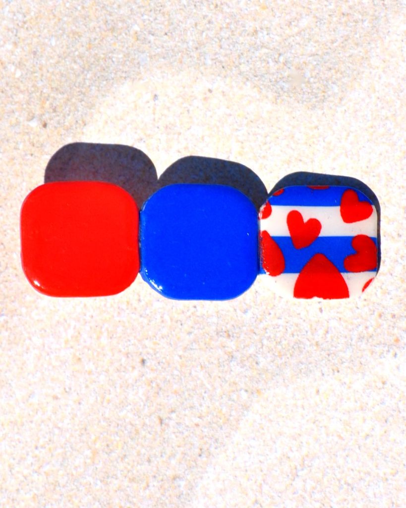 Barrette composée de trois carrés retro, un rouge vif, un bleu éclatant et un motif marinière cœurs rouges.