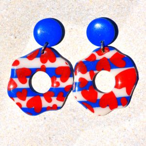 Paire de boucles d'oreilles en forme de "fleurs" abstraites motif marinière cœurs rouges, surmontées d'une puce ronde unie bleue éclatant.
